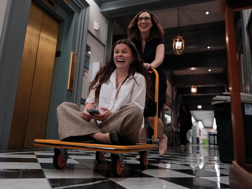 U.S.-Rep.-elect Sarah McBride, D-Del., speeds her incoming Deputy Chief of Staff and Communications Director, Michaela Kurinsky-Malos, through the halls of Delaware Legislative Hall on a moving cart as they move out of McBride's Delaware state senate office in Dover, Del. Photo by Carolyn Kaster, AP.